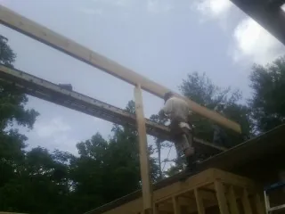 Carpenter setting a ridge beam over a new addition frame — Ice Dam Removal by Roofing Brothers in St Columbans