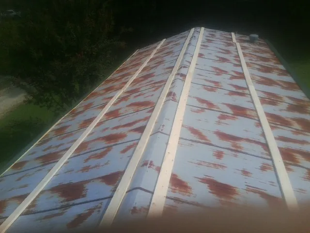 Rusted metal roof panels with new wood purlins before replacement — Storm Damage Roof Repair in St Columbans by Roofing Brothers
